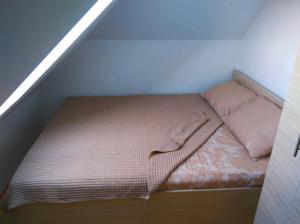 a small bed in a small room in a attic at Apartman Malina in Zlatibor