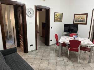 a living room with a table and chairs and a clock at Appartamento Matilde in Brindisi
