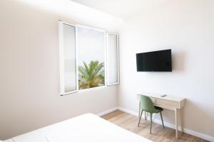 阿爾本加的住宿－Albium - Hotel Sul Mare，一间卧室配有一张床、一张书桌和一个窗户。