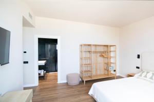 a bedroom with a white bed and a desk at Albium - Hotel Sul Mare in Albenga