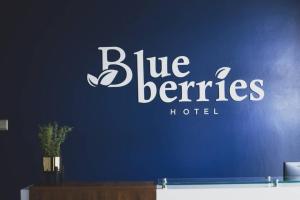 un cartel azul del hotel Beneficios en una pared azul en Blueberries Hotel en Entebbe