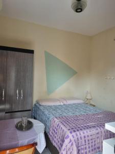 1 dormitorio con 1 cama con colcha púrpura en Sua casa fora de casa, en João Pessoa