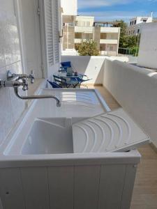 a white sink in a bathroom on a balcony at Le Giraffe ( n.CIS LE07503191000035725) in Rivabella