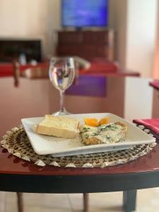 un plato de queso y una copa de vino en una mesa en Casa Beija-Flor, 