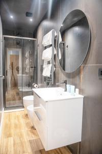 een badkamer met een wastafel, een toilet en een spiegel bij Albium - Hotel Sul Mare in Albenga