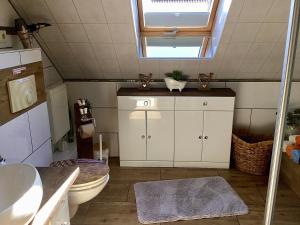 uma casa de banho com um WC, um lavatório e uma janela em Apartment Eichwald em Sexau