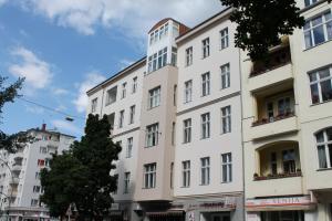a tall white building with a tree in front of it at Motel Blue - Minimalist Boutique Hotel in Berlin