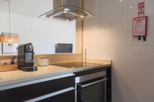 a kitchen with a sink and a counter top at Republica Deluxe Apartment in Vila Nova de Gaia