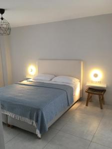 a bedroom with a bed with two lamps on it at DION APARTMENTS in Paleros