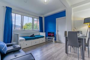 倫敦的住宿－Bright 1 Bed Flat near London Bridge，一间拥有蓝色墙壁的卧室,配有一张床和一张桌子
