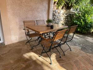 勒旺的住宿－Rez de jardin, entre mer et montagne，一张木桌,上面有两把椅子和一株植物
