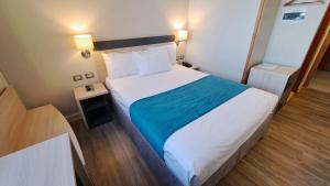 a bedroom with a large bed with a blue blanket at Hotel Diego de Almagro Calama Express in Calama
