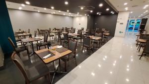 a restaurant with tables and chairs in a room at Hotel Diego de Almagro Calama Express in Calama