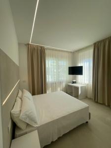 1 dormitorio blanco con 1 cama grande y TV en Room Corso 219, en Montesilvano