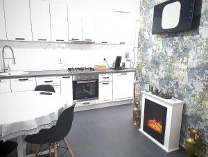 a kitchen with a table and a stove and a fireplace at Modern Central Apartament in Câmpulung Moldovenesc