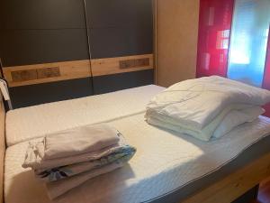 two beds with white sheets and towels on them at Ferienwohnung Regau 