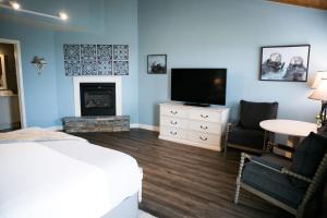 een slaapkamer met een bed, een tv en een open haard bij Sea Otter Inn in Cambria