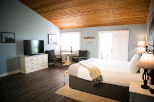Schlafzimmer mit einem Bett, einem Schreibtisch und einem TV in der Unterkunft Sea Otter Inn in Cambria