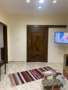 a living room with a wooden door and a rug at Darkum Apartment in Wadi Musa