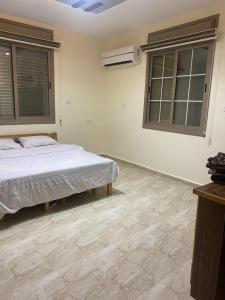 a bedroom with a bed and two windows at Darkum Apartment in Wadi Musa