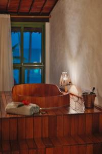 a room with a tub with a lamp on a table at Pousada Rota Ecológica in Pôrto de Pedras