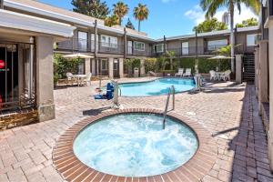 a hot tub in the middle of a courtyard with a house at Del Sol Inn Anaheim in Anaheim