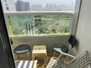 einen Balkon mit 2 Stühlen, einem Tisch und einem Fenster in der Unterkunft شقة مفروشة دبي in Ajman 