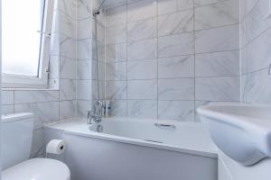 La salle de bains est pourvue d'une baignoire, de toilettes et d'un lavabo. dans l'établissement Bright 1 Bed Flat near London Bridge, à Londres