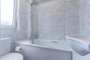 a bathroom with a tub and a toilet and a sink at Bright 1 Bed Flat near London Bridge in London