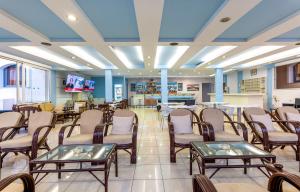 een wachtkamer in een ziekenhuis met tafels en stoelen bij Anixis Hotel & Apartments in Ialyssos