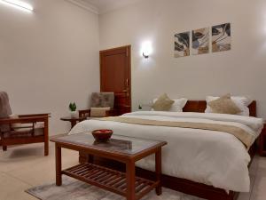 um quarto de hotel com uma cama grande e uma mesa em The Cana's Coorg em Ammatti