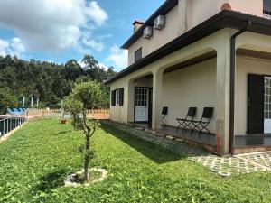 ein Haus mit zwei Stühlen auf dem Vorgarten in der Unterkunft Martins House in Vila Viçosa