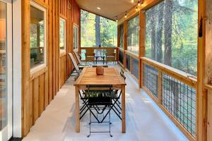 a screened porch with a table and chairs on it at Modern Beaver Valley Cabin with Hot Tub and Games! in Leavenworth