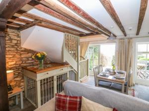 a living room with a table and chairs at Red Fawn Cottage in Blockley