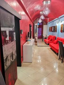 sala de estar con paredes rojas y sofá rojo en Bilocale tipico, nel centro del Salento, en Galatina