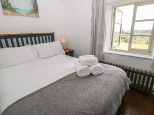 a bedroom with a bed with two towels on it at Red Fawn Cottage in Blockley