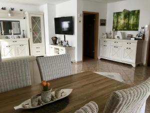 uma sala de estar com uma mesa de madeira e cadeiras em Apartment Eichwald em Sexau