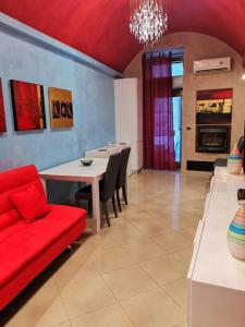 sala de estar con sofá rojo y mesa en Bilocale tipico, nel centro del Salento, en Galatina