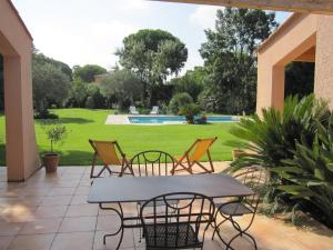 une terrasse avec une table, des chaises et une piscine dans l'établissement Maison Parc Ducup, à Perpignan