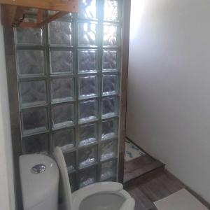 a bathroom with a toilet and a glass block wall at Studio Norte, Casa Brisamar in Puerto Morelos