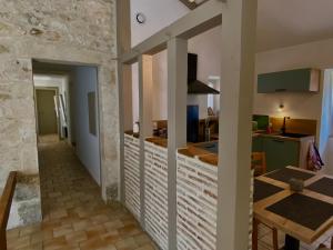 a kitchen and living room with a table and a counter at Gite de Claire Fontaine avec vue sur Monflanquin in Monflanquin