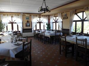 a restaurant with white tables and chairs and windows at Rincón De Pepe in El Castell de Guadalest