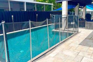 a fence around a swimming pool with blue water at *BEST House in MIAMI - Pool, Fashion, Central in Tamiami