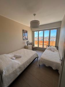 1 dormitorio con 2 camas y ventana grande en Cannes Satellite, en Cannes