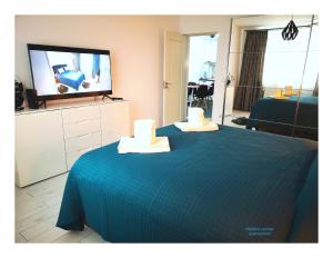 Habitación con TV y cama con toallas. en Modern Central Apartament, en Câmpulung Moldovenesc