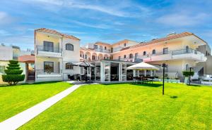 a large building with a lawn in front of it at Anixis Hotel & Apartments in Ialysos