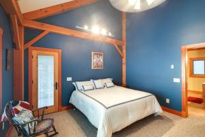 a bedroom with a bed and a blue wall at Lake View Champlain Home with Hot Tub and Sauna! in Melville Landing