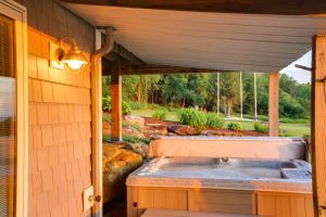 a jacuzzi tub in the back of a house at Lake View Champlain Home with Hot Tub and Sauna! in Melville Landing +32 photos
