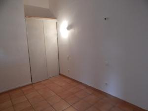 an empty room with a door and a tile floor at F3 HOCHE 2 éme étage in Coursan +2 photos