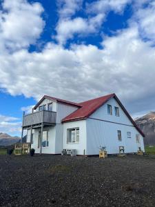 una gran casa blanca con techo rojo en Sauðanes Guesthouse, en Höfn